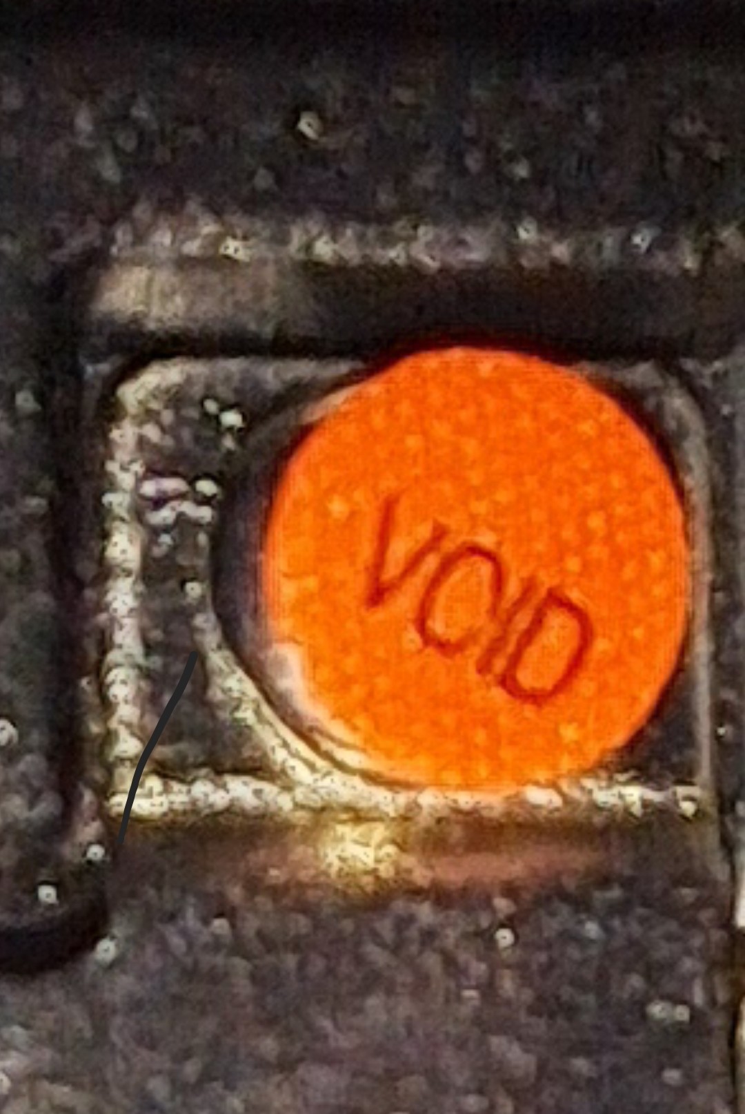 A very zoomed up picture to a screw in some piece of hardware, covered with s red sticker, labeled VOID.