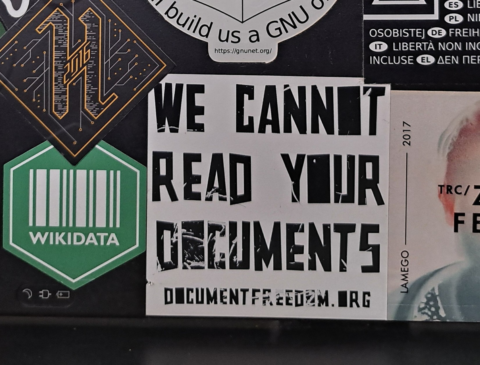 A few stickers on a laptop, the central one saying "We Cannot Read Your Documents", and pointing to documentfreedom.org