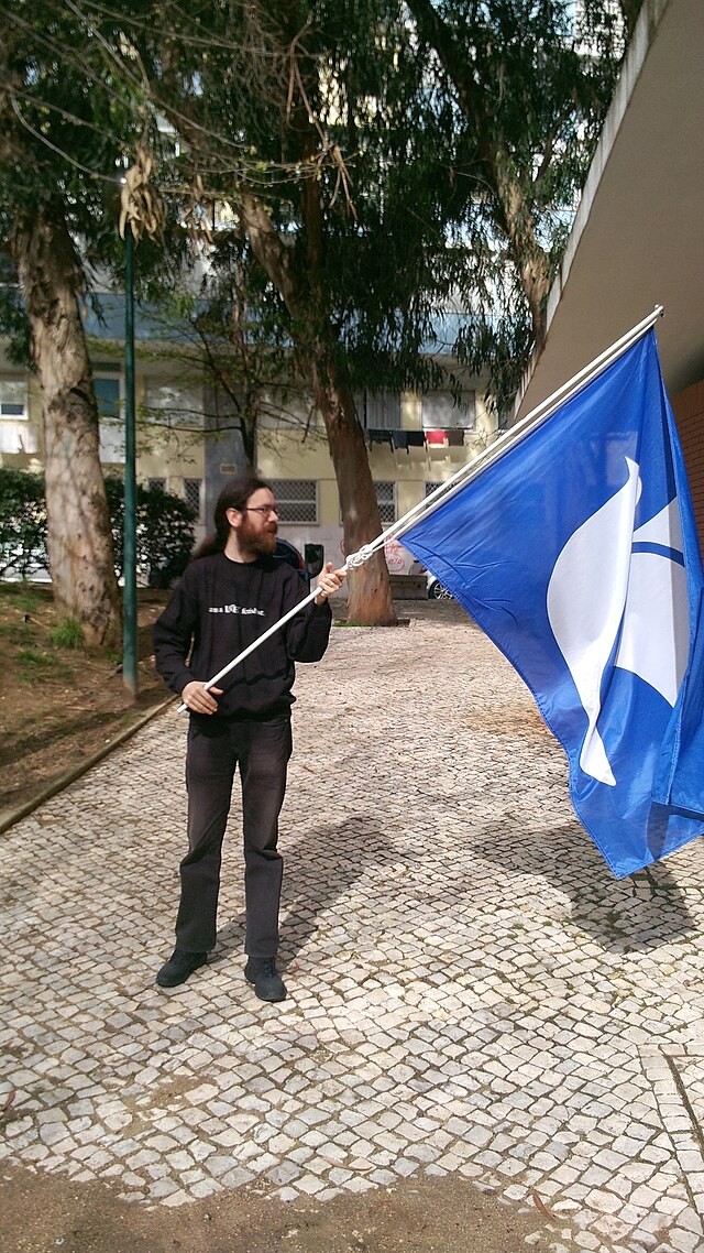 Me waving (or mostly holding) an ODF flag, outdoors, while wearing a LaTeX sweatshirt. Picture taken during the first day of Document Freedom Day 2013 celebrations in Lisbon.