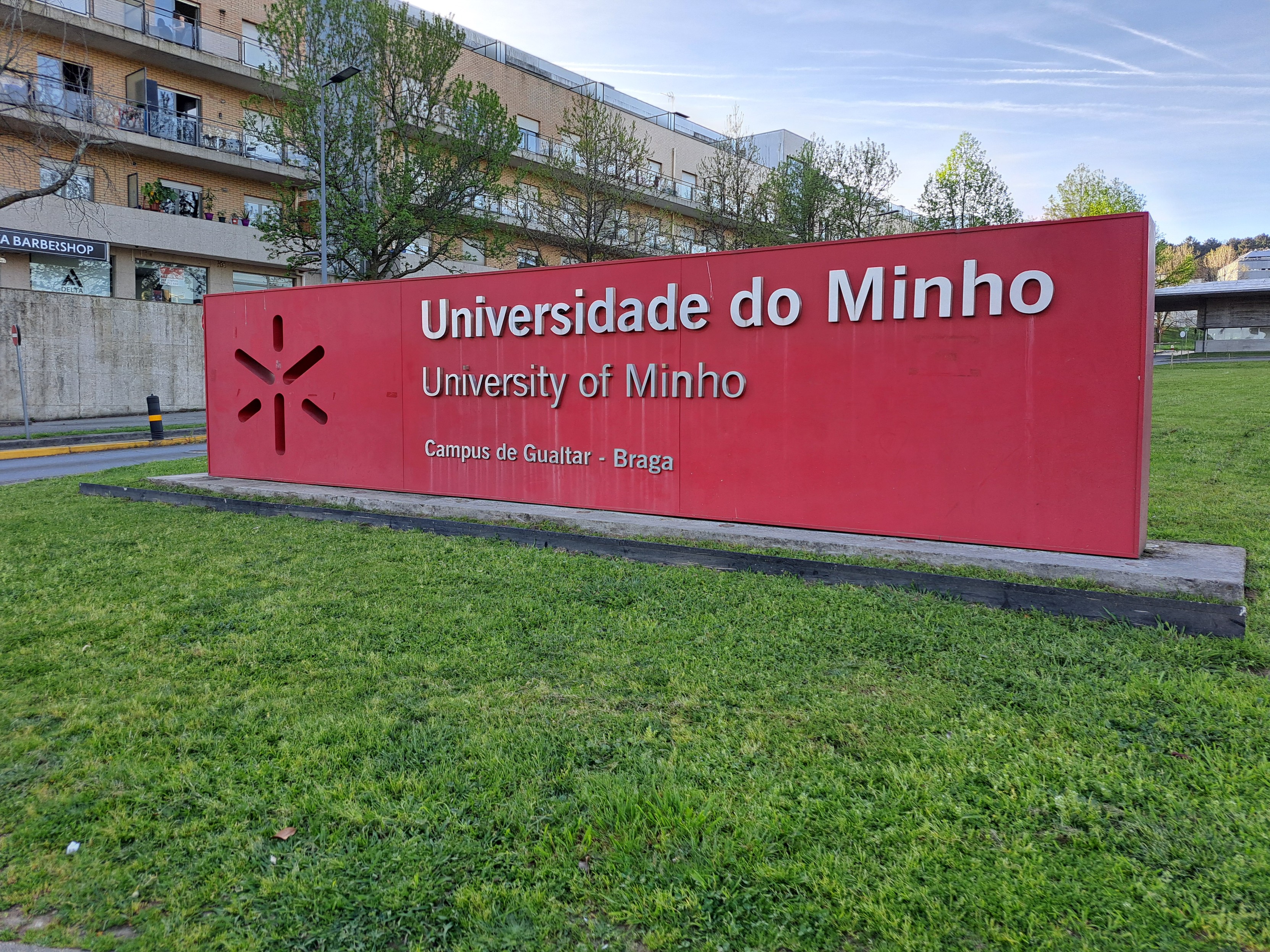 um sinal vermelho com o logotipo e o nome da Universidade do Minho à entrada da universidade