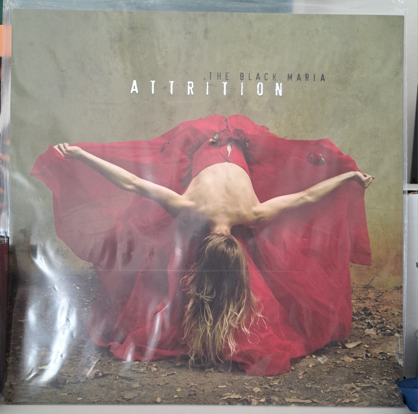 A picture of &ldquo;The Black Maria&rdquo;, this year&rsquo;s Attrition album, in its LP version. Its cover is the picture of a woman in a red dress bowing down.