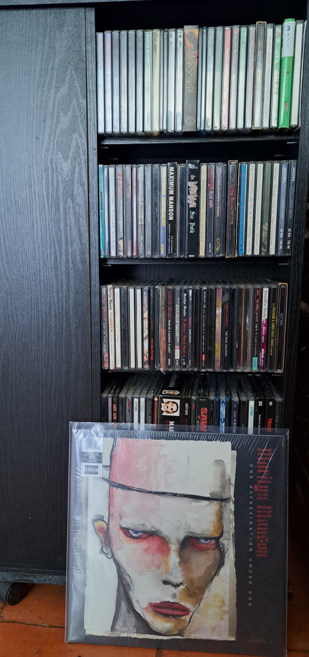 Marilyn Manson&rsquo;s &ldquo;One Assassination Under God - Chapter 1&rdquo; vinyl record in front of a CD shelf full of other Manson records